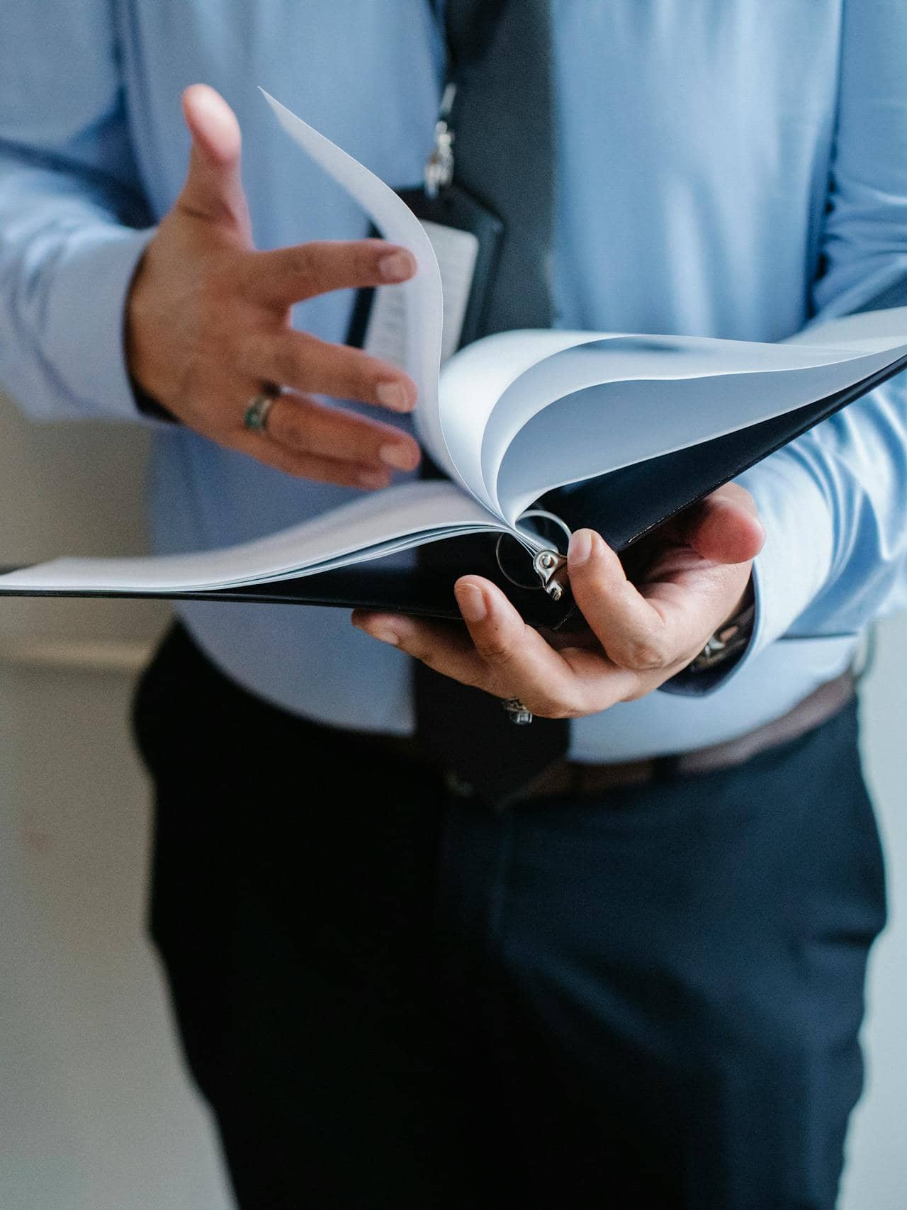 man flipping through papers in a binder